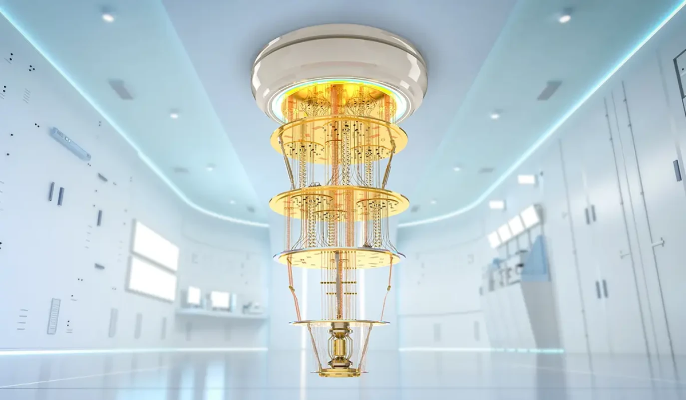 Ein Quantencomputer mit einer mehrschichtigen, goldfarbenen Kühlstruktur hängt von der Decke in einem hochmodernen, futuristisch wirkenden Labor. Der Raum ist hell beleuchtet, mit weißen Wänden, integrierter LED-Beleuchtung und technischen Geräten im Hintergrund.